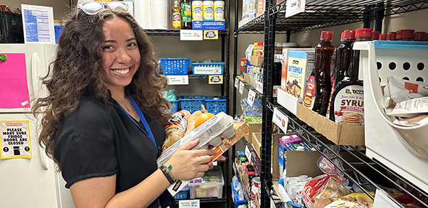 Student stocking items in the Student Cupboard